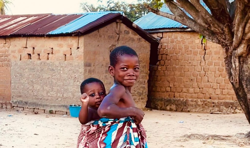 a girl is carrying her child on her back